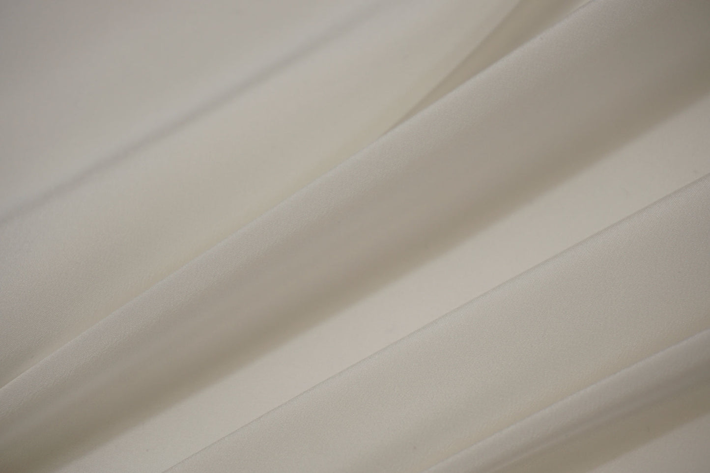Detailaufnahme italienischer Seidencrêpe – feinkörnige Textur, matte Oberfläche, weich, fließend und hochwertig für Couture-Designs