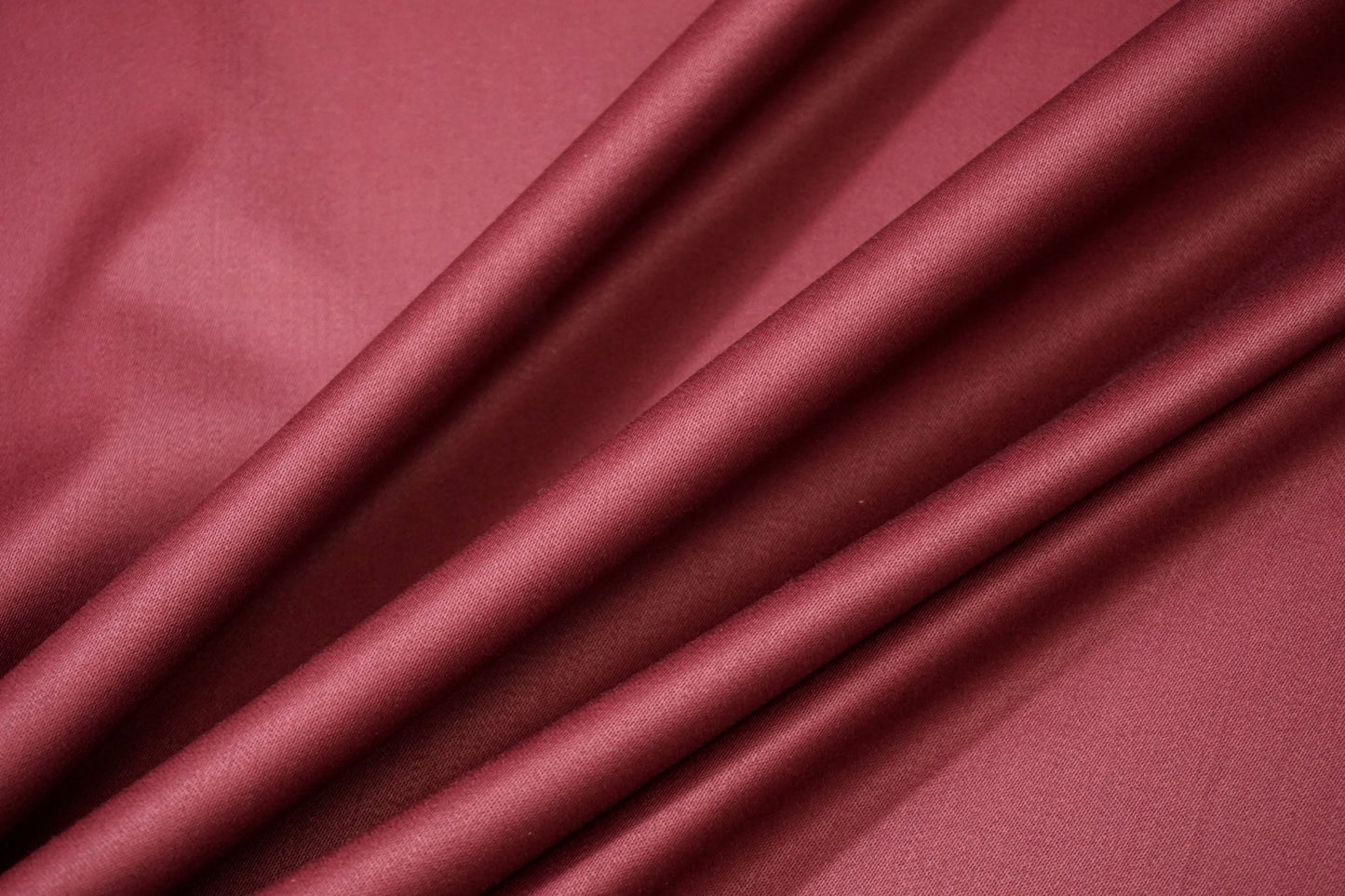 Detailaufnahme italienischer Schurwoll-Anzugstoff in Beere – feine, doppelseitige Struktur, leicht satiniert, ideal für Blazer, Hosen oder Kleider