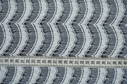 Nahaufnahme der französischen Spitze mit feiner, wellenförmiger Struktur und eleganter Transparenz