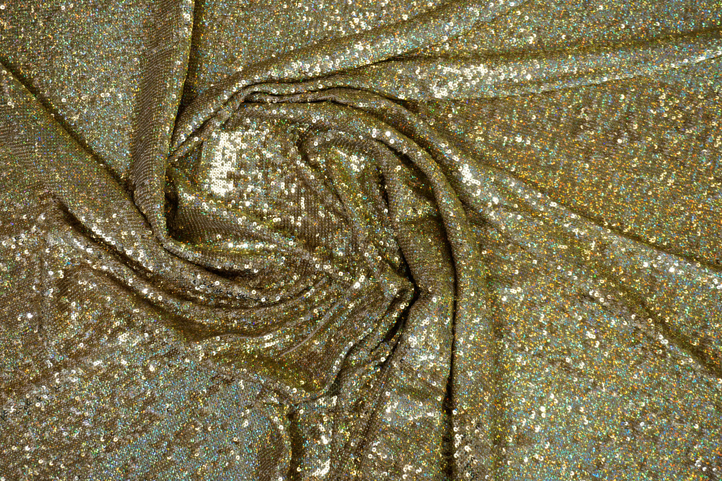 Luxuriöser Paillettenstoff in Gold mit irisierendem Regenbogeneffekt auf hellem Nude-Tüll