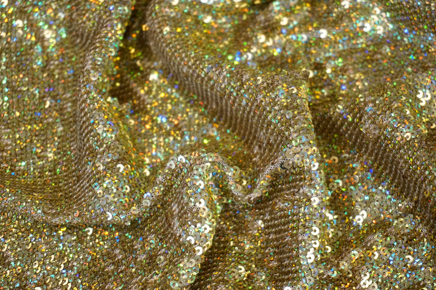 Nahaufnahme der dicht gesetzten goldenen Pailletten mit holografischem Farbspiel