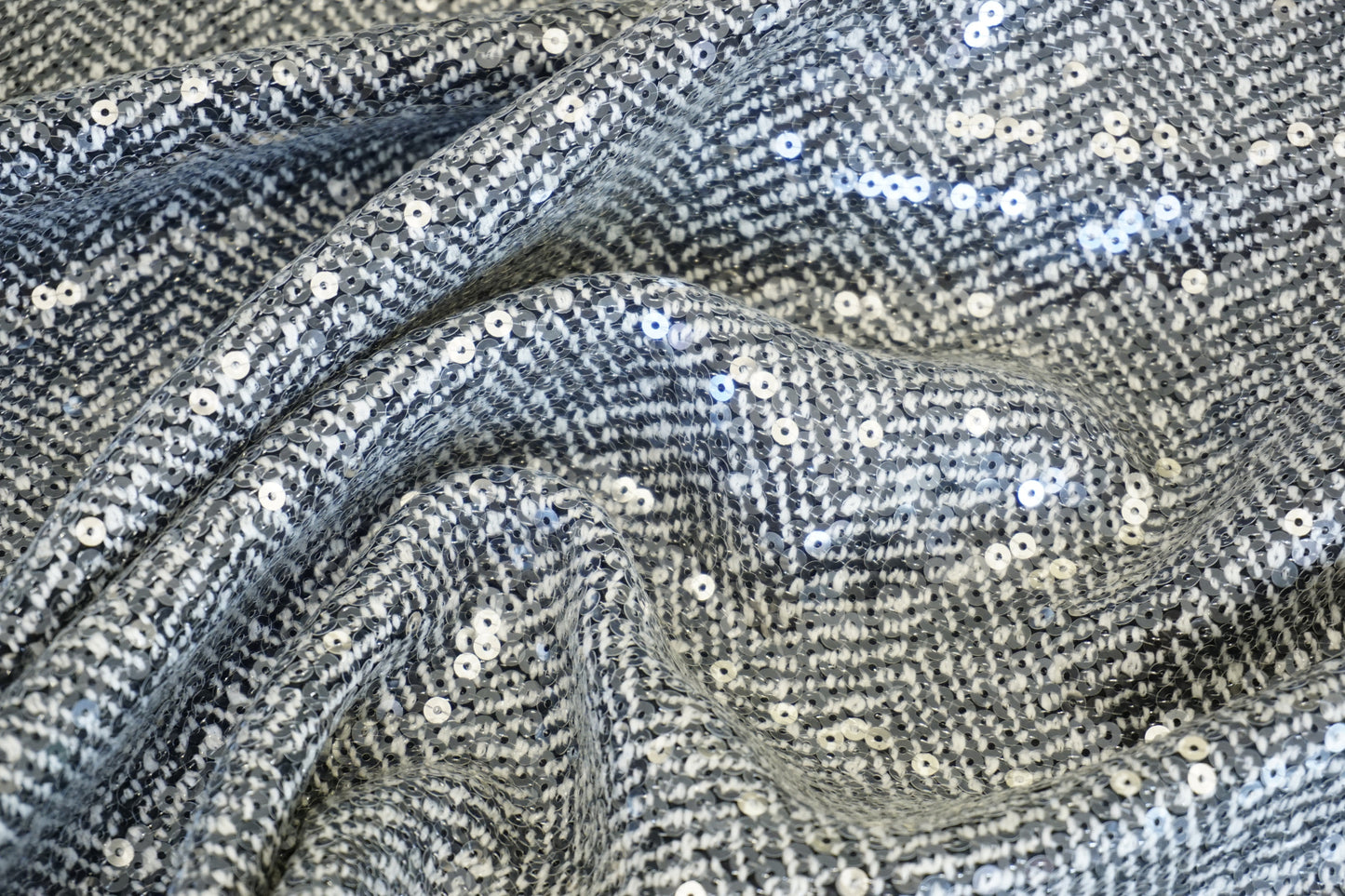 Exklusiver Chevron-Mantelstoff – Fischgrät-Optik mit Pailletten-Glow