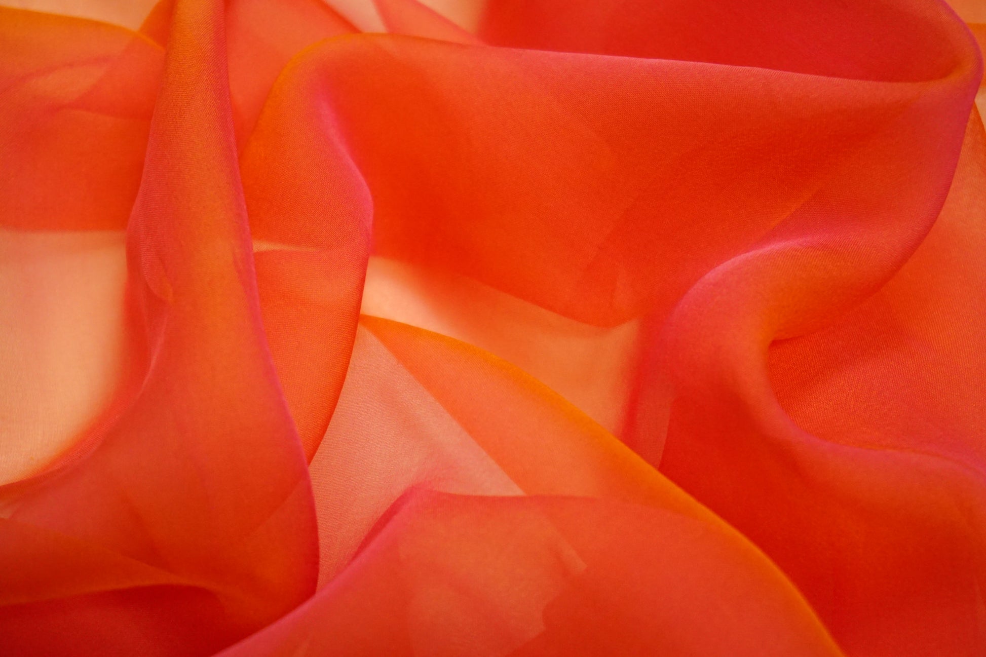 Nahaufnahme exklusiver Seidenchiffon in warmen Sonnentönen
