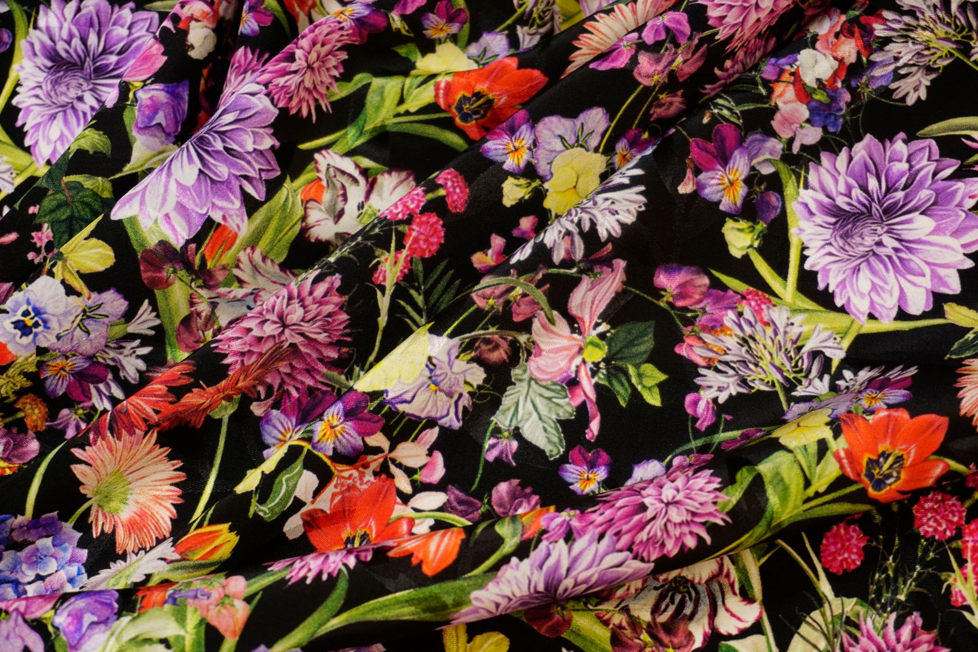 Detailaufnahme des Jacquards – feine Struktur, leichter Schimmer und lebendige florale Muster auf schwarzem Grund