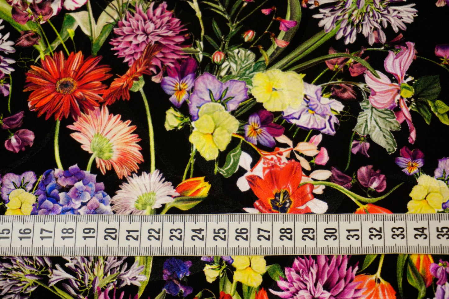 Detailaufnahme der farbenfrohen Blumen auf Jacquard mit Maßband – edle Textur, lebendige Farben und luxuriöser Fall