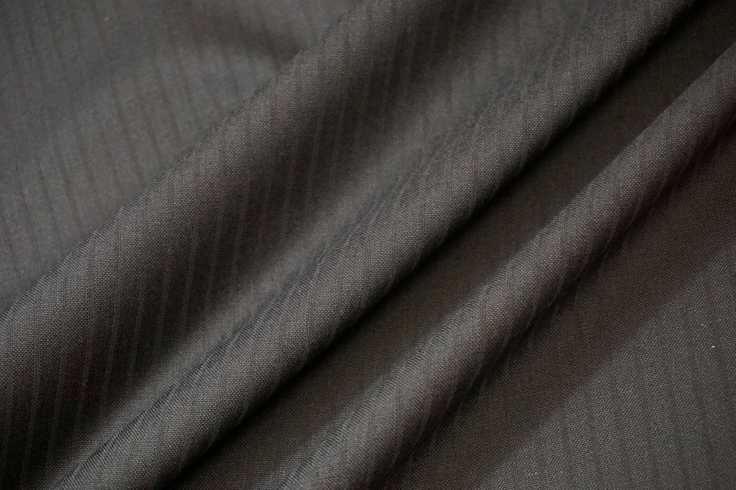 Nahaufnahme der feinen Jacquard-Streifen im schwarzen Schurwollstoff