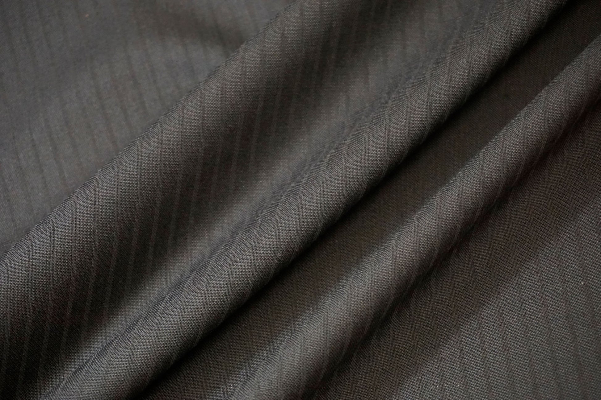 Nahaufnahme der feinen Jacquard-Streifen im schwarzen Schurwollstoff