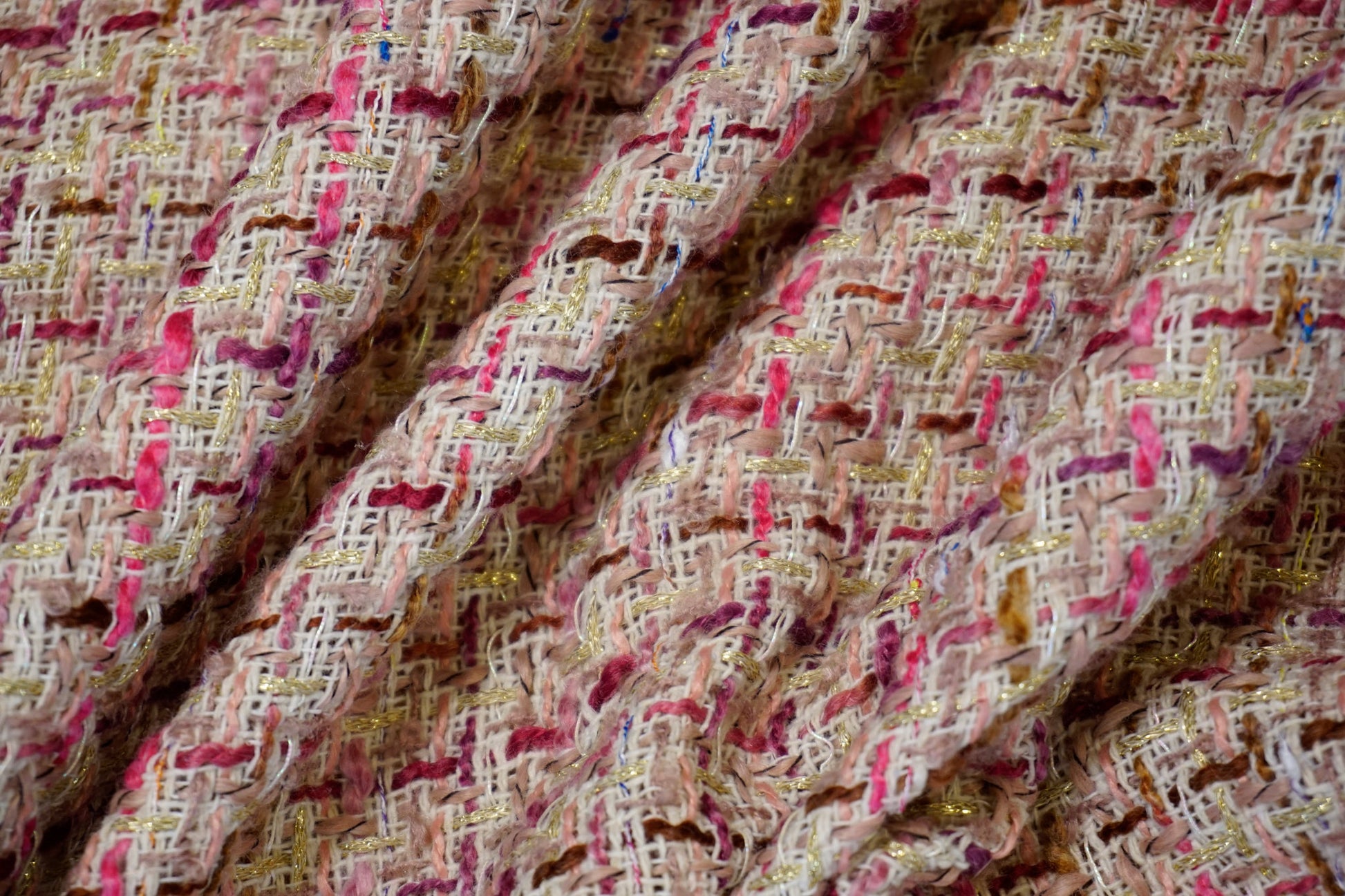 Nahaufnahme der plastischen Bouclé-Struktur mit verwobenen Garnschlingen in Rosé und dezenten Farbakzenten