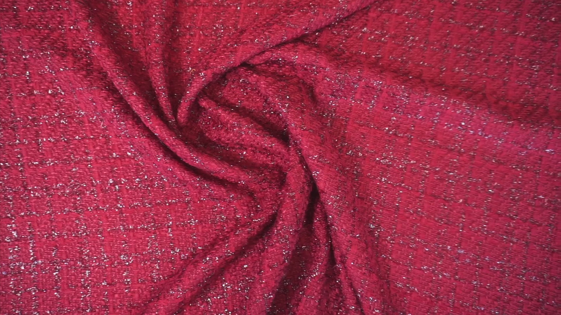 Rubinroter Bouclé-Stoff mit funkelnden Lurex-Akzenten und plastischer Struktur bei Bewegung